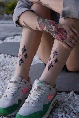 Photo of a female's legs showing neo-traditional tattoos on her arms and legs