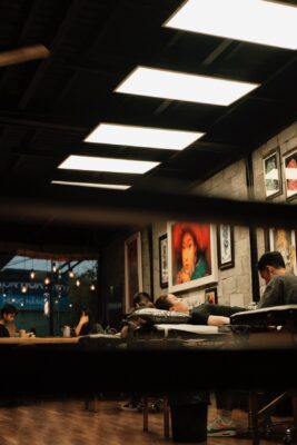 Photo of the inside of The Hangout Tattoo studio showing an artist tattooing from a distance