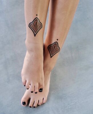 Lower shin tattoo of a brown and black ornamental designs