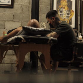 How Much Are Tattoos in Hoi An? The little picturesque town that is Hoi An, is renowned for its rich cultural heritage, charming old town, and vibrant local arts scene. Among the many artistic expressions thriving in all corners of this little town, you’ll end up coming across tattoo art. For locals and tourists alike, getting a tattoo in Hoi An can be a memorable and meaningful experience. It’s also important to understand the pricing situations in Vietnam, which can help you with planning your trip and budgeting accordingly to ensure you have spare dollar-doos to drop on a cool new piece. Factors That Influence Tattoo Prices The cost of a tattoo in Hoi An, just as in other areas of the world, varies based on several factors. It’s also worth remembering that when it comes to tattoos - you get what you pay for. We’ll go into a bit of a list to give you a breakdown of how it works. 1. Size and Complexity: Larger tattoos with intricate designs require a lot more time and effort, which then results in higher pricing. It also depends on what is included in the design (circles and clean straight lines typically increase the price of a tattoo due to the expertise needed to perform the task, for example). Simpler designs and smaller pieces will typically be less expensive. 2. Artist’s Experience and Reputation: Seasoned tattoo artists with a solid reputation often charge more for their expertise, which is understandable. Their experience in the field ensures high-quality work, which many clients are willing to pay a premium for, as with tattoos the focus should be on the quality of tattoo, not the quantity. 3. Colour vs. Black and Grey: Colour tattoos generally cost more than black and grey, due to the additional time and materials required (additional inks, needles etc). 4. Studio Location and Amenities: Studios located in prime tourist areas or those offering high end experiences might charge more compared to smaller and less central shops, as getting a new tattoo is a huge experience in itself - it’s not just about the end product. As an example, here at The Hangout Studio, we offer free consultations as well as free refreshments to our clients during their time with us. Typical Price Range Based on research online as wella s feedback from travellers and locals, we have an approximate breakdown of tattoo prices in Hoi An. Please keep in mind that it also depends on the complexity of the design, as well as individual pricing at different studios - some studios may charge by piece, whereas some other studios may charge an hourly rate. It’s also worth mentioning that most studios have a minimum price, due to the cost of materials used for setting up their station for your tattoo. 1. Small Tattoos (1-3 inches): You’d be expecting to pay between 500,000 and 2,000,000 (approximately $25-85 USD). These are usually simple designs such as symbols, linework or minimalistic art. 2. Medium Tattoos (4-6 inches): These can range from 2,000,000 to 5,000,000 VND (roughly $85-215 USD). Medium sized tattoos often involve more details, as well as more areas to shade and colour, so typically take longer to complete and require additional expertise. 3. Large Tattoos (7 Inches and above): Prices for larger pieces can start from around 6,000,000 VND (around $230 USD) and can go upwards of 10, 20, or 30 million VND ( $390 USD - $1200 USD), but this depends on the complexity and time required, as well as the body part that is being tattooed. Tips For Getting A Tattoo In Hoi An 1. Research and Reviews: Before choosing a studio, be sure to read reviews online and look at the artists portfolios to ensure their style aligns with your vision. You can check out our review page on Google here. 2. Consultation: Schedule a consultation to discuss your design, get a price estimate, and gauge the artist’s expertise. This will also give you the chance at scoping out the studio and seeing if the vibe of the place vibes with what you’re looking for. 3. Hygiene Standards: Ensure the studio you choose follows strict hygiene practices, including the use of sterilised equipment and single use disposable needles. 4. Aftercare: It’s important to follow the aftercare instructions provided by the artist to ensure proper healing and the longevity of your tattoo and to make sure it’s still looking fresh in years to come. 5. Environment: Vietnam is a hot country, and humans tend to sweat when it’s hot - surprise surprise. Be sure to request additional information on aftercare tips when in a foreign country and in a different climate than you’re used to. Conclusion Getting a tattoo in Hoi An can be a unique and rewarding experience that can capture the essence of your visit to this enchanting little town. With a range of studios and prices to suit different budgets, it’s important you do your research and choose an artist who can bring your vision to life in a safe and professional environment. Whether you’re commemorating your trip or just indulging in some additional body art, Hoi An’s art and tattoo scene offers something for everyone.